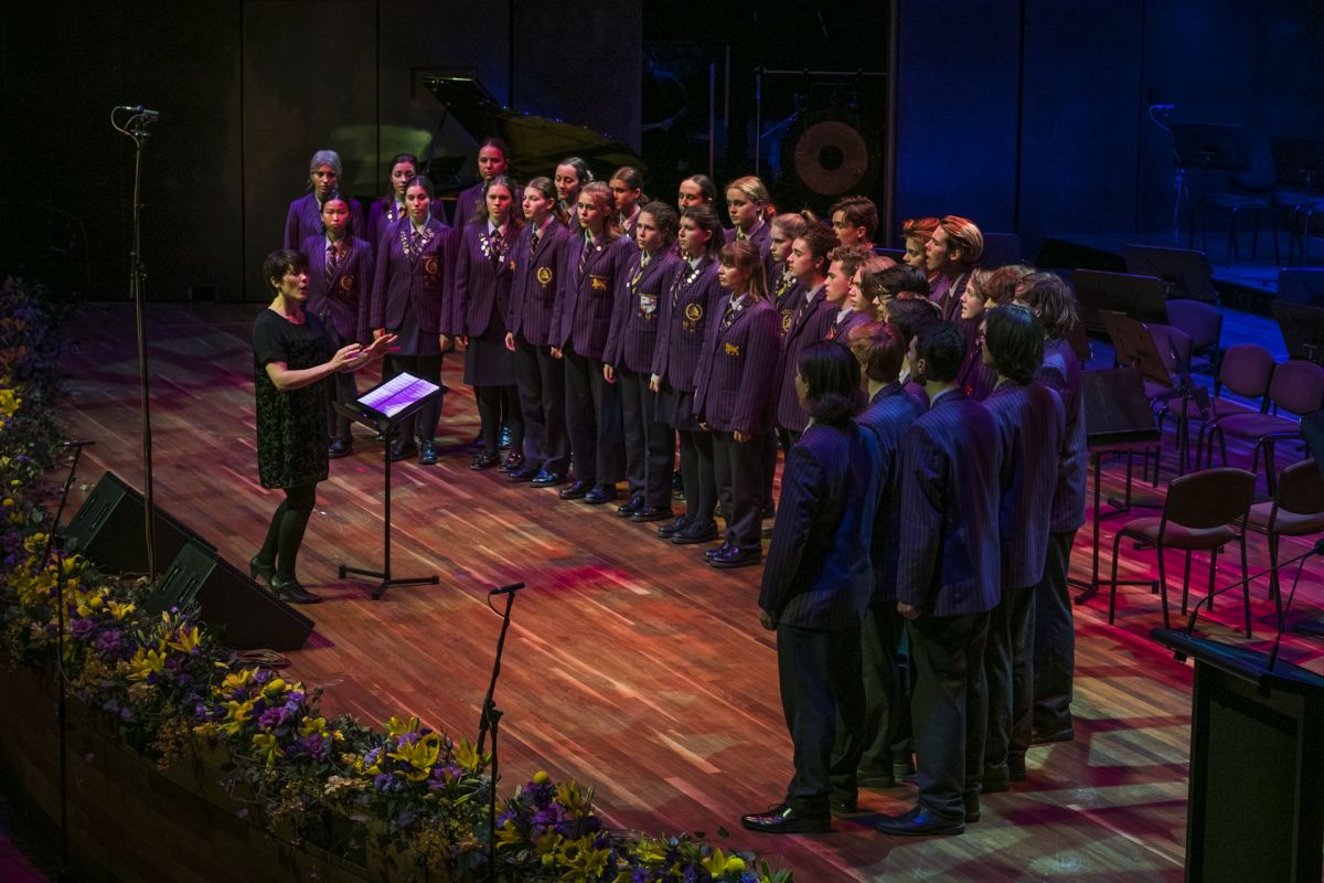 Wesley choir students standing in a semi circle facing the conductor