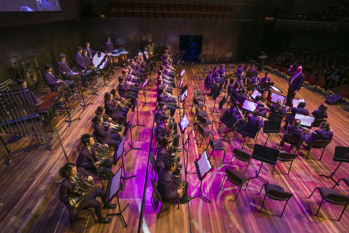 An overhead view of Wesley Orchestra with percussion, strings, woodwind, brass and a conductor at the front