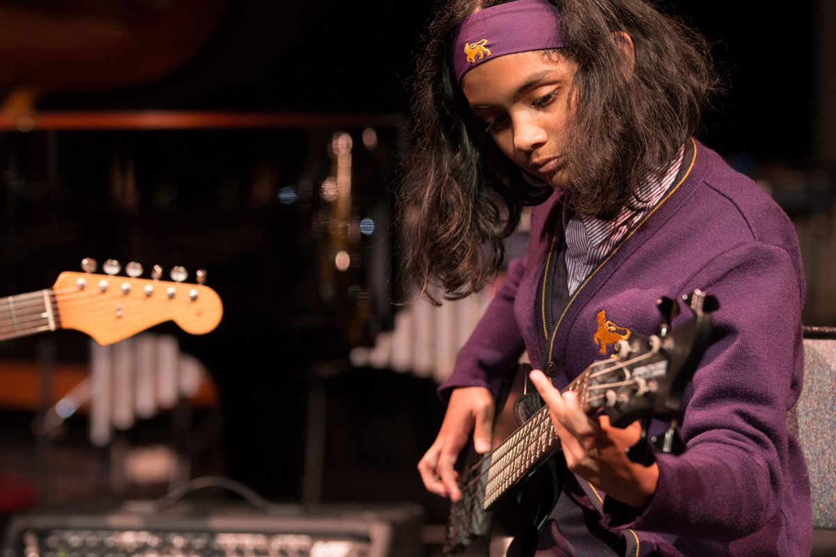 A Wesley student playing an electric bass