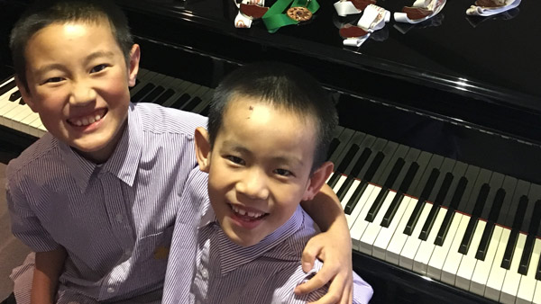 Two students, Lionel and Dillon, with a piano