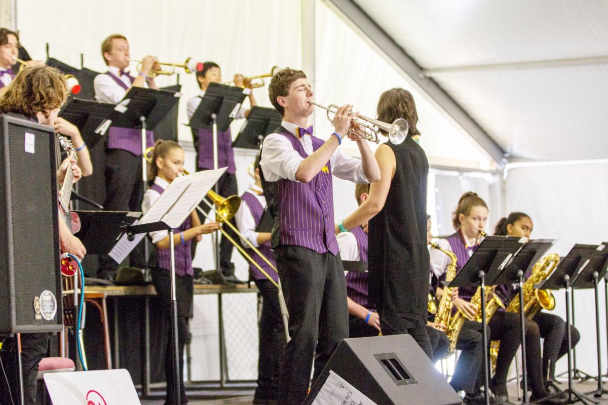 A group of students playing brass instruments on stage