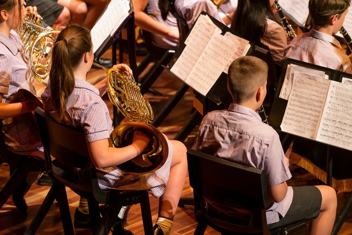 Students performing on musical instruments on stage