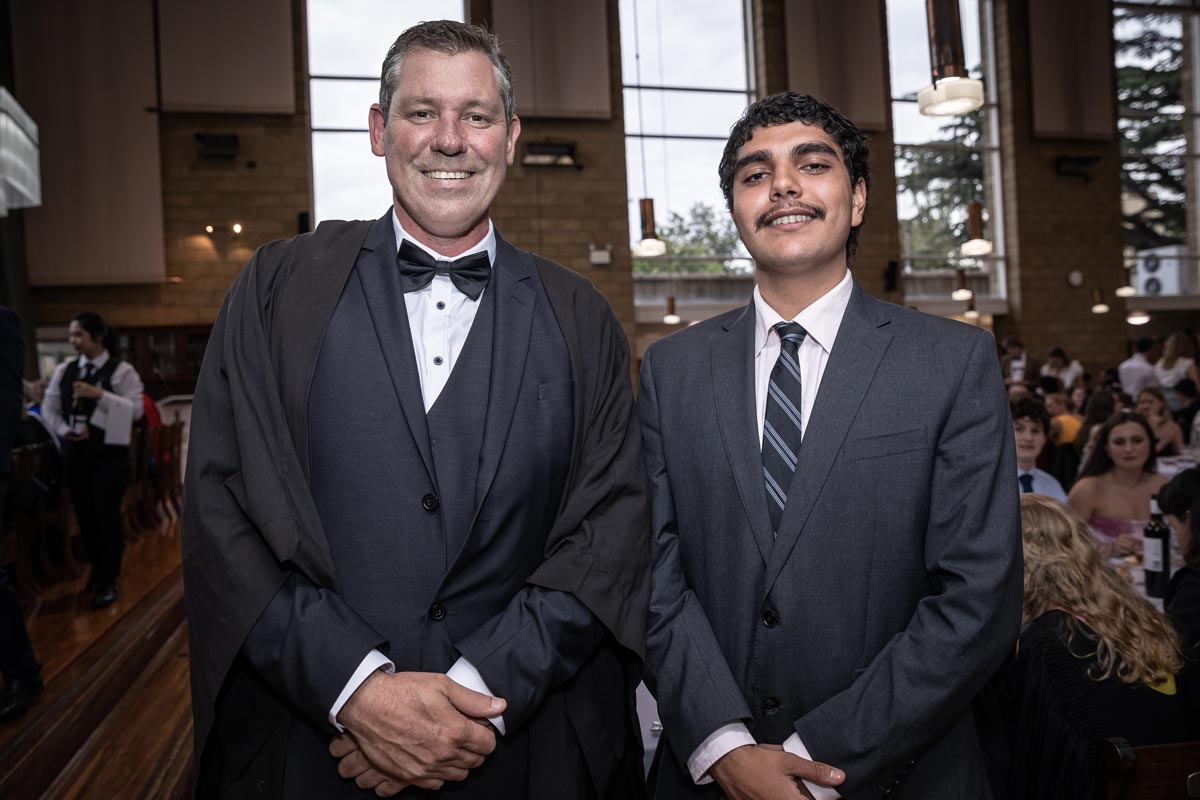 Teacher Matt Watson and student Briggs McIntosh standing in dinner suit at the Queens College function
