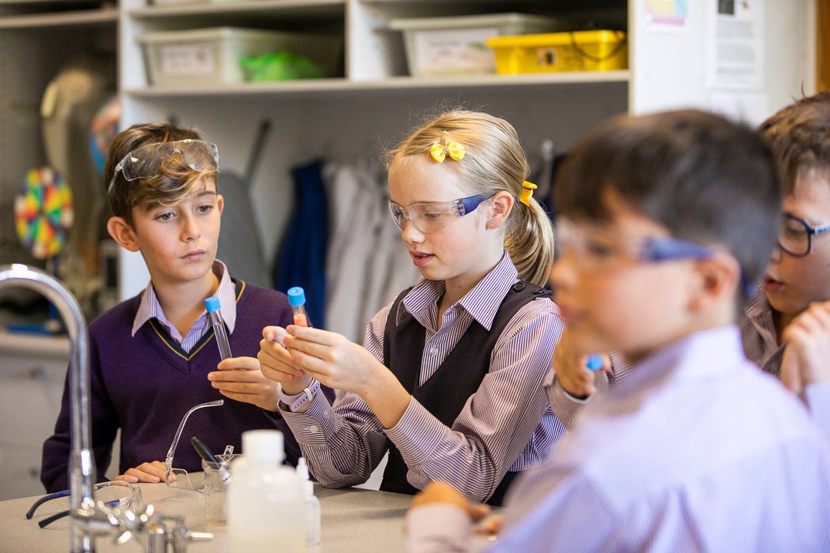 Two students studying test tubes in the science lab