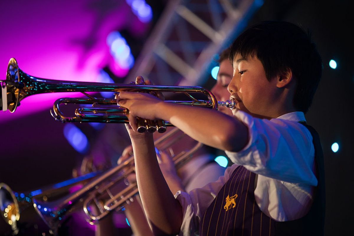 A close up of a Wesley student playing the trumpet