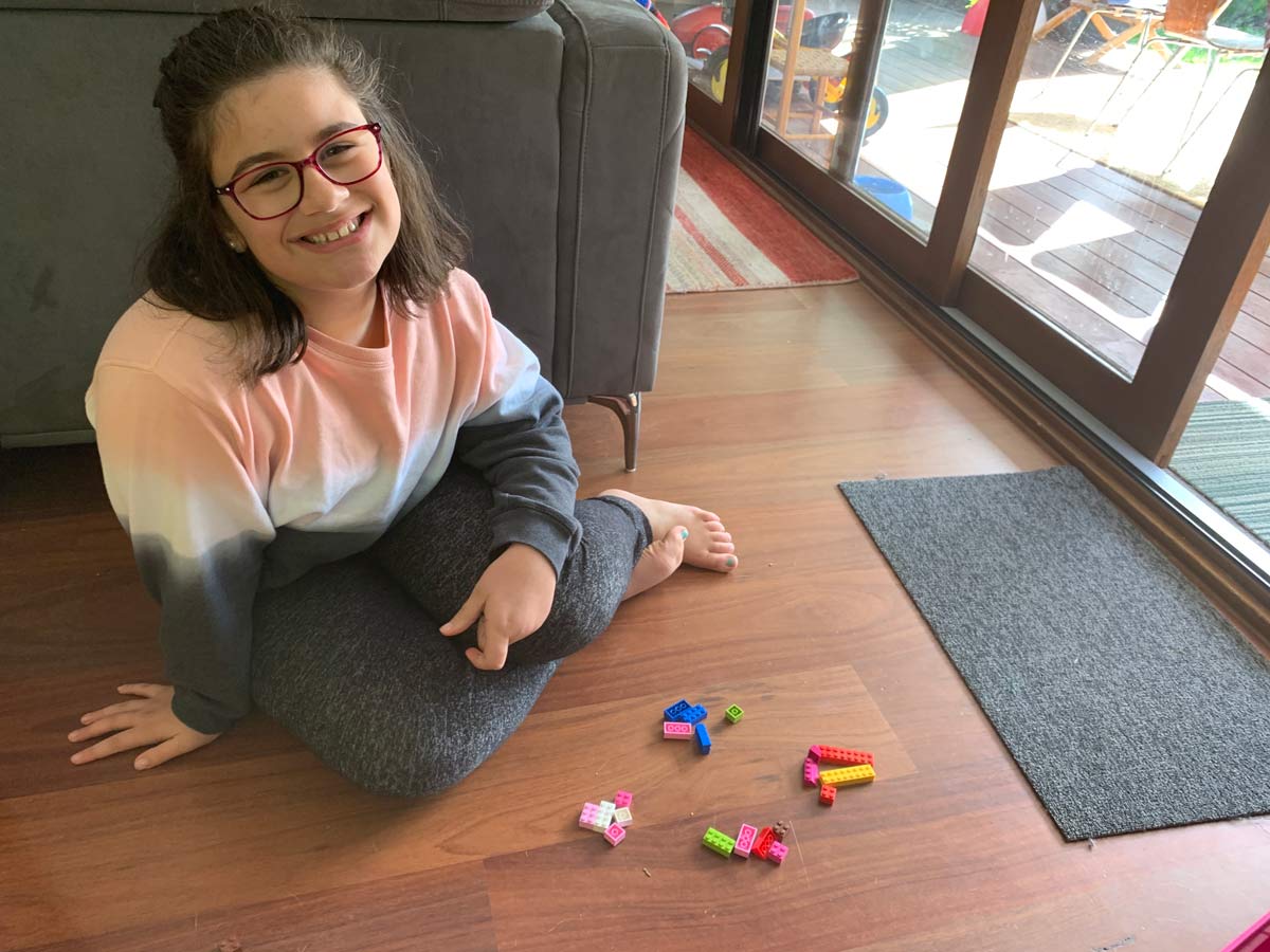 Maya Portelli sitting with Lego blocks around her on the floor