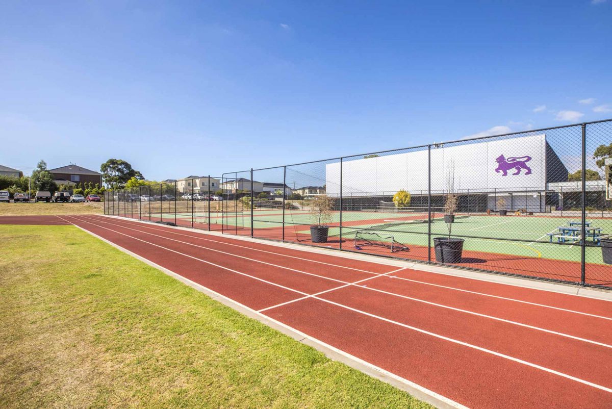 An athletics running track with courts in the background