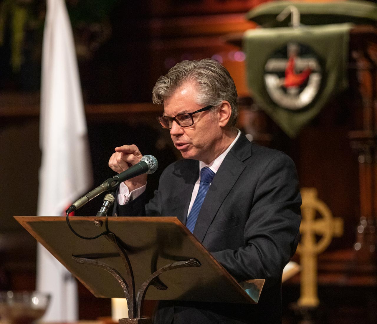 Principal Nick Evans makes a speech at a lectern in a hall