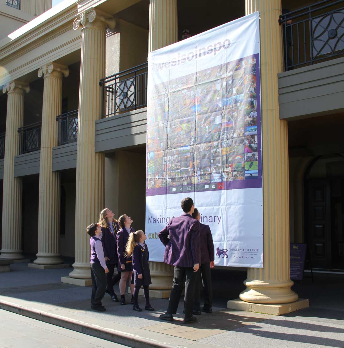 Students admire a banner of images taken in iso