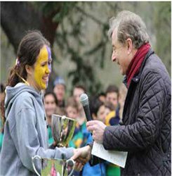 Leigh Roux, captain of the Girls’ Cross Country team is presented with the             Premiership Cup by Tom Batty, Headmaster of Scotch College