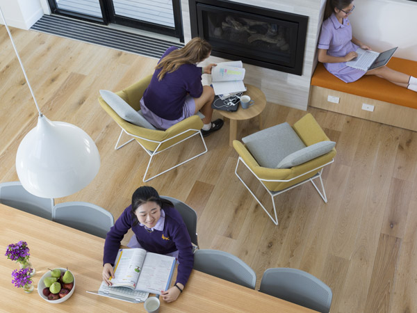 Four students play with a circular wooden toy