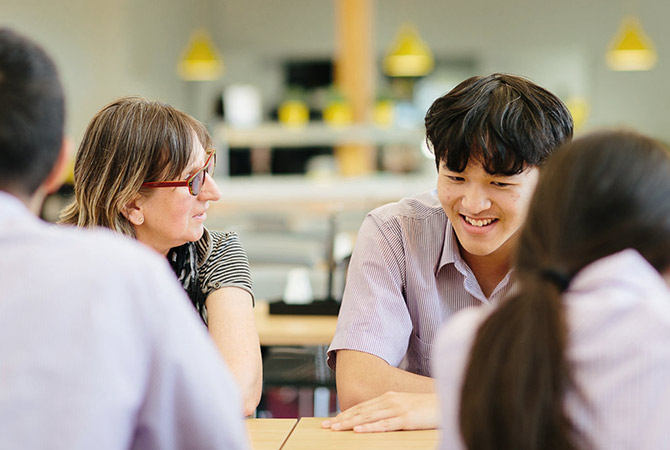 A male student talking to a teacher