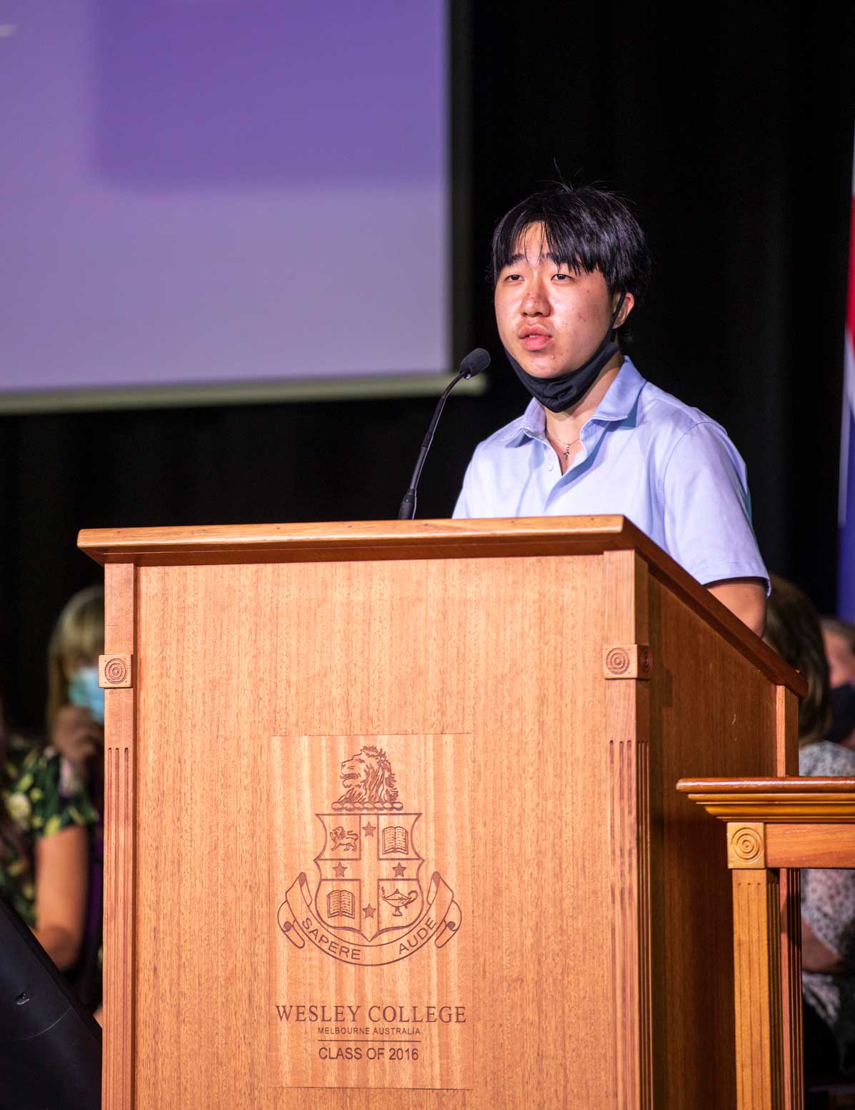 Kean Tan stands at the lectern giving the Scholar's Address at assembly