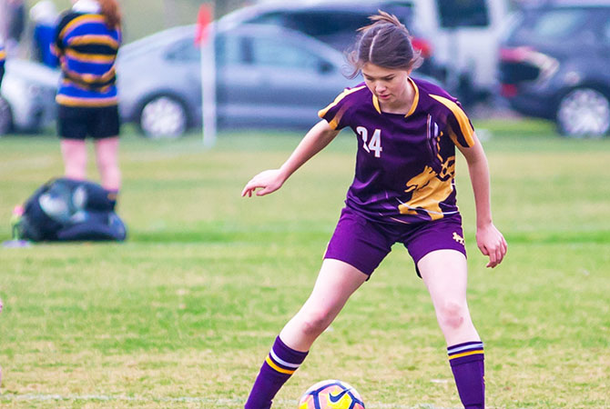 A female student playing soccer
