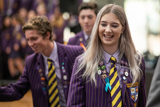 A female school captain walking while smiling and laughing