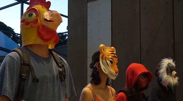 Student actors in a film wearing animal masks and holding plastic guns