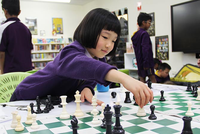A young female student playing chess