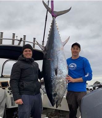 Michael Dockery and his friend hold up their giant tuna