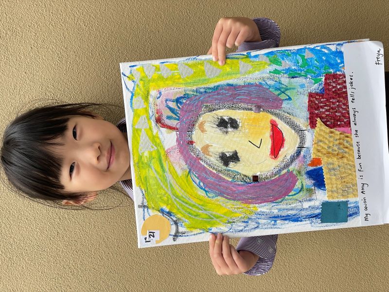 Student Freya holds up portrait he has painted