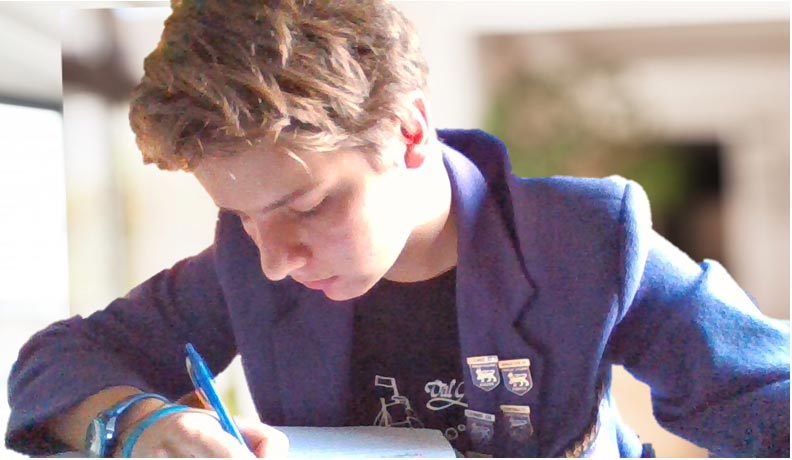 Boy studying while wearing a purple blazer, from a previous iteration of the Wesley uniform