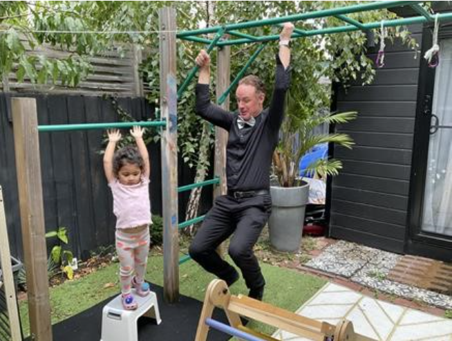 Student and educator play on monkey bars