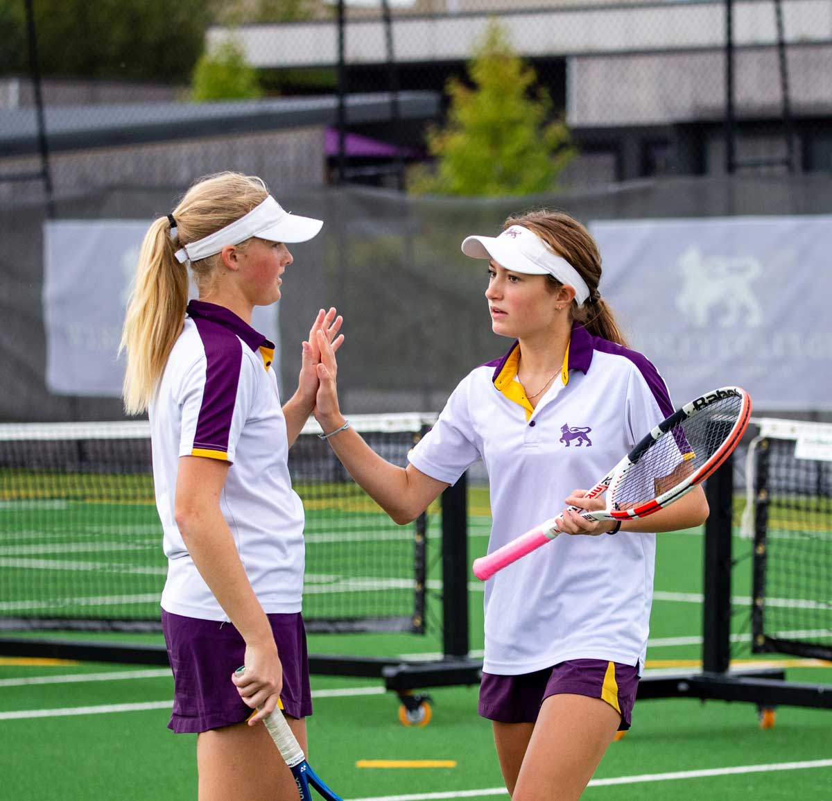 Girls tennis players high-five each other