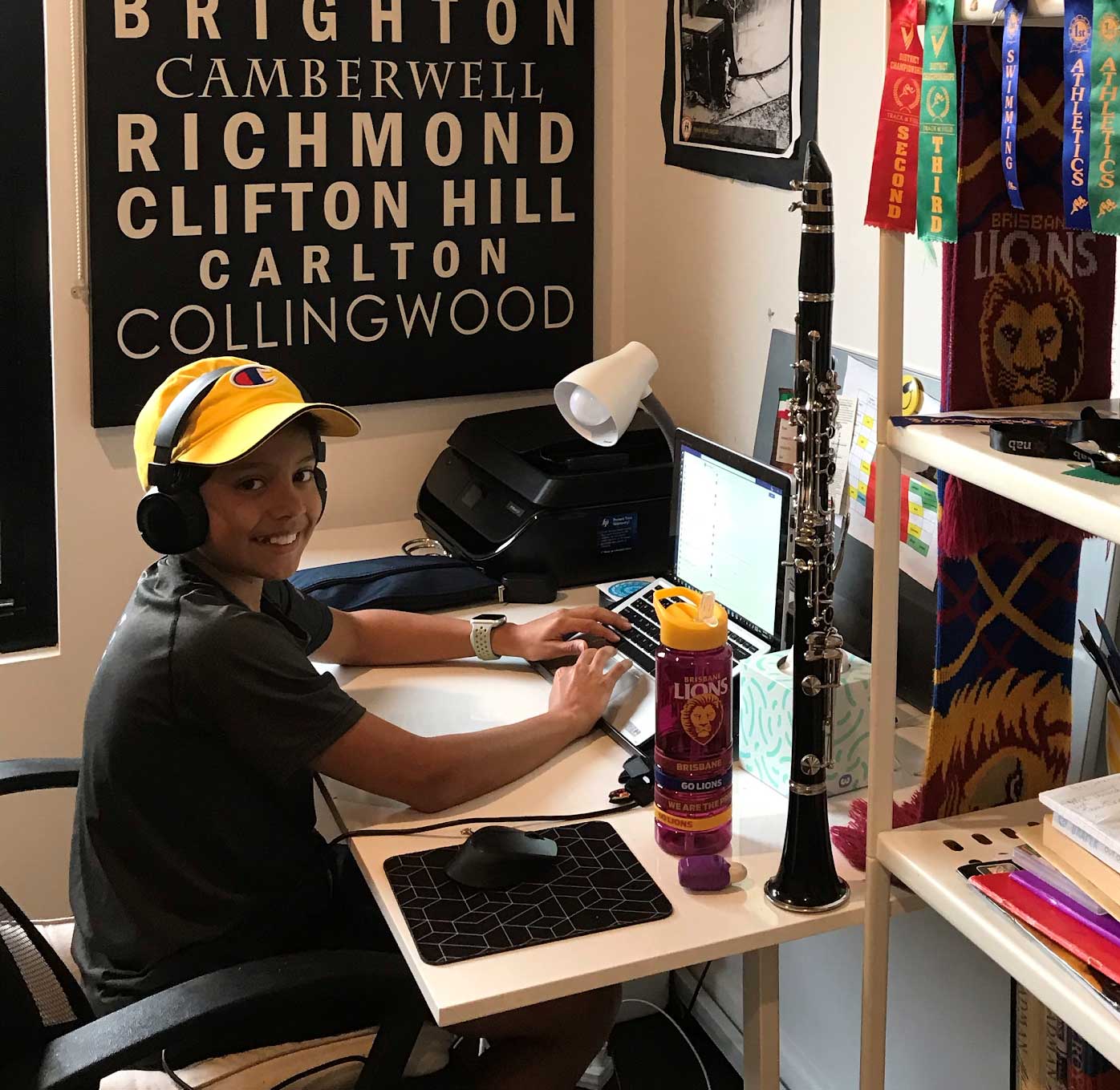 Student Tahj Megna sits at his desk with his clarinet beside him, remote learning at home